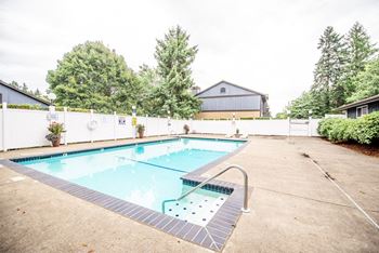a swimming pool in a backyard with a fence
